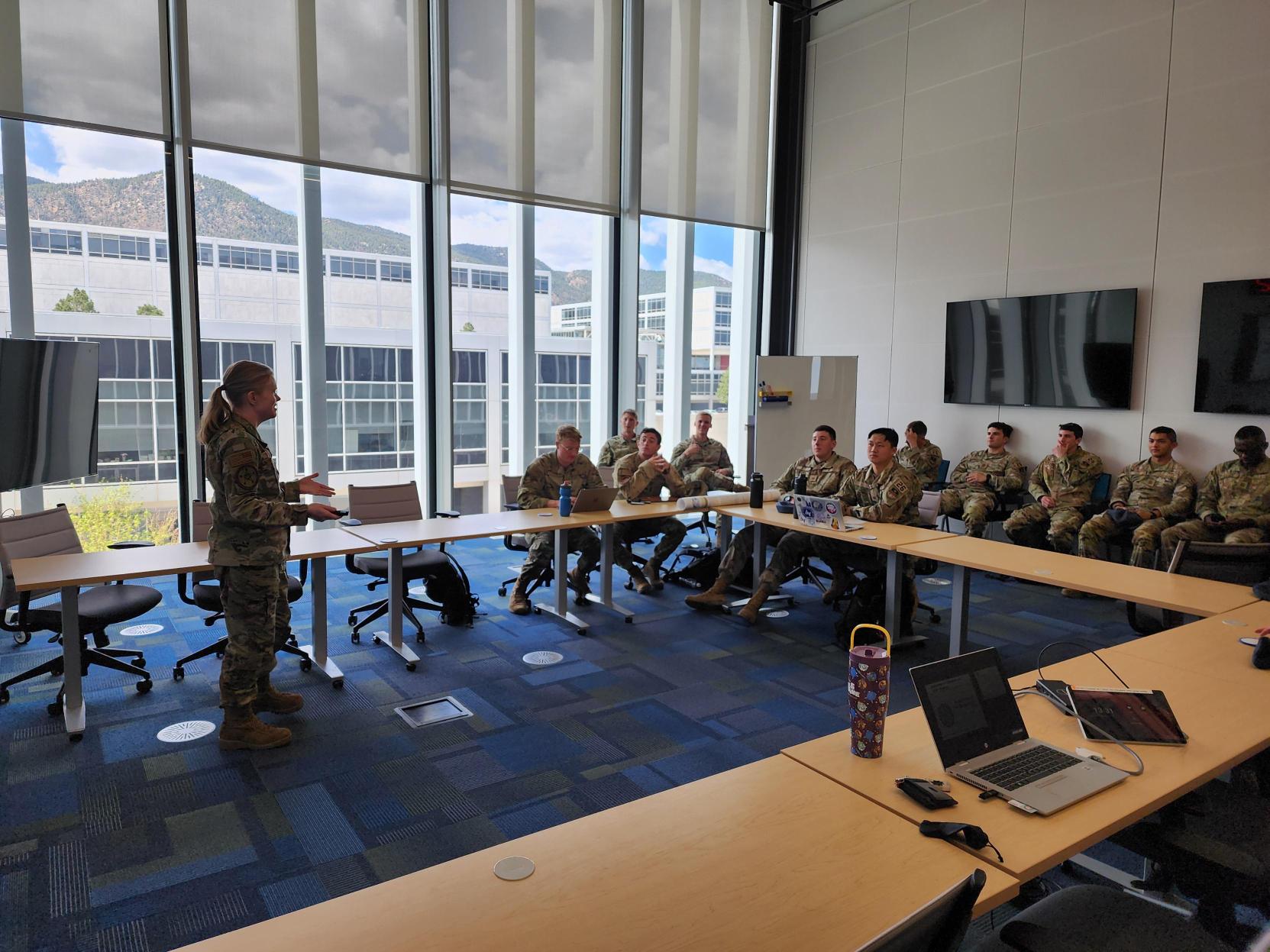 Teaching cadets in a USAFA classroom, mountain view through the window